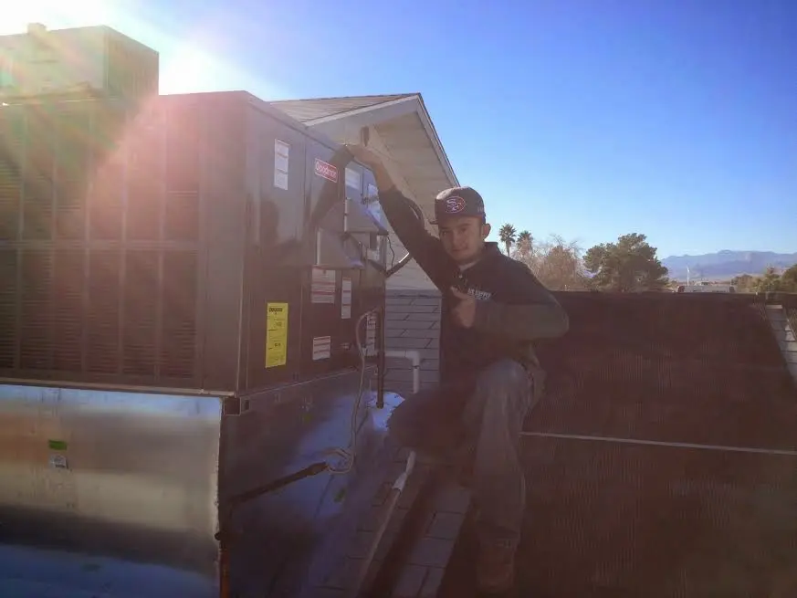 HVAC technician performing HVAC Inspection on a rooftop unit in Sterling